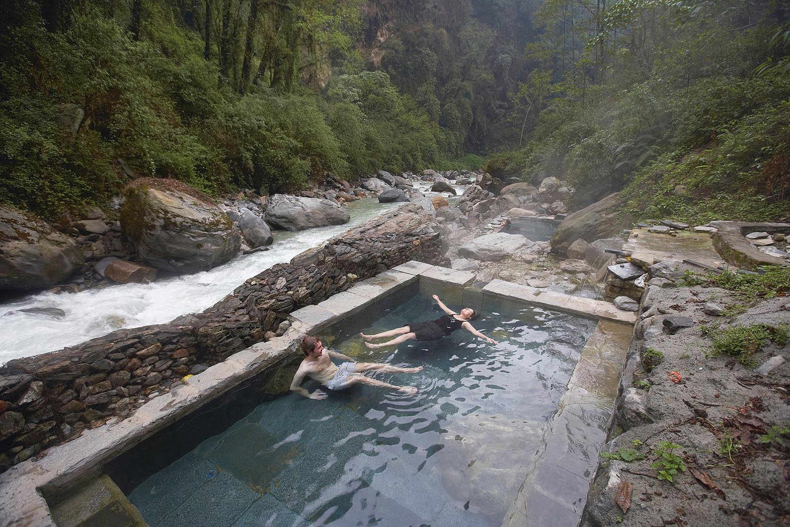 Trekkers relaxing in the hot springs near Chhomrong on the Annapurna circuit trek, Nepal