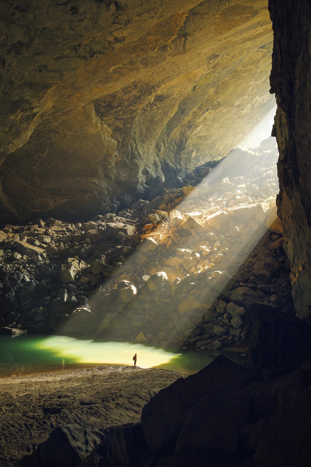 A caver illuminated by a sunbeam in Hang En Cave, Vietnam.