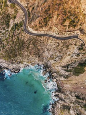 credit: jacoblund / Getty ImagesAerial view of road going through beautiful landscape. Rocky scenery close to the ocean.