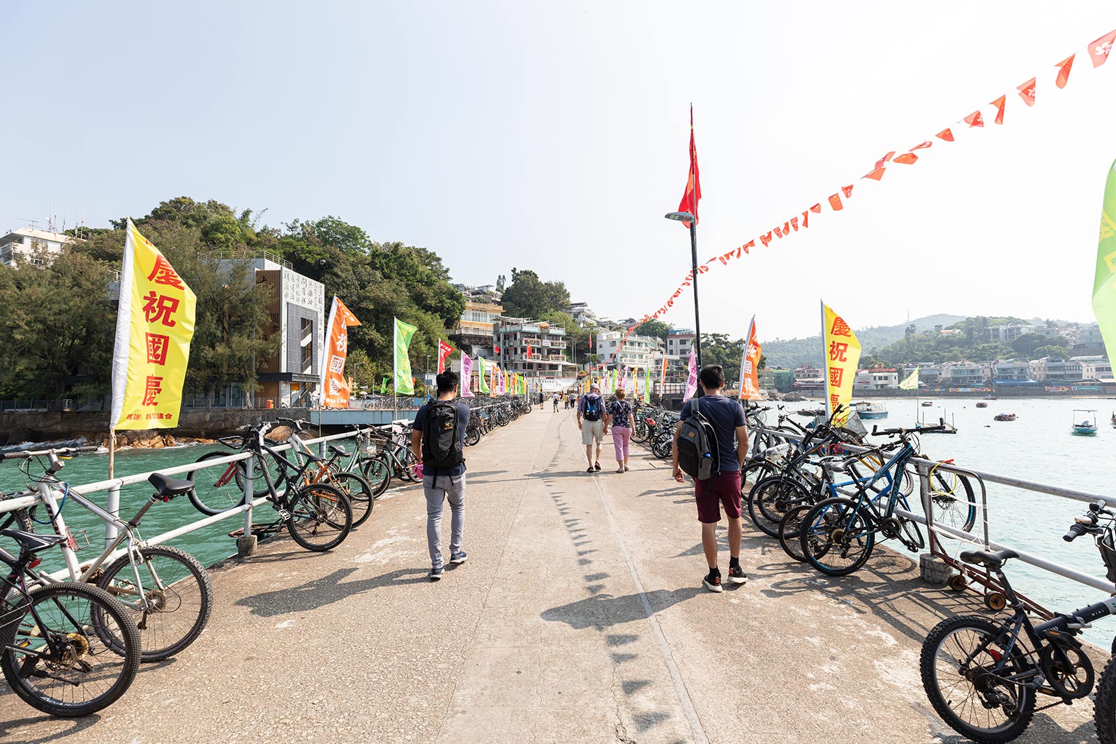 Visitors walk along Lamma Island pier, lined with bicycles