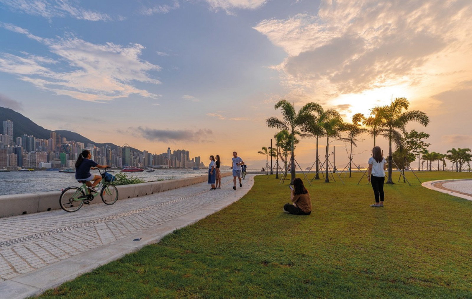 People bike and hang out at Art Park along the West Kowloon harbourfront in Hong Kong