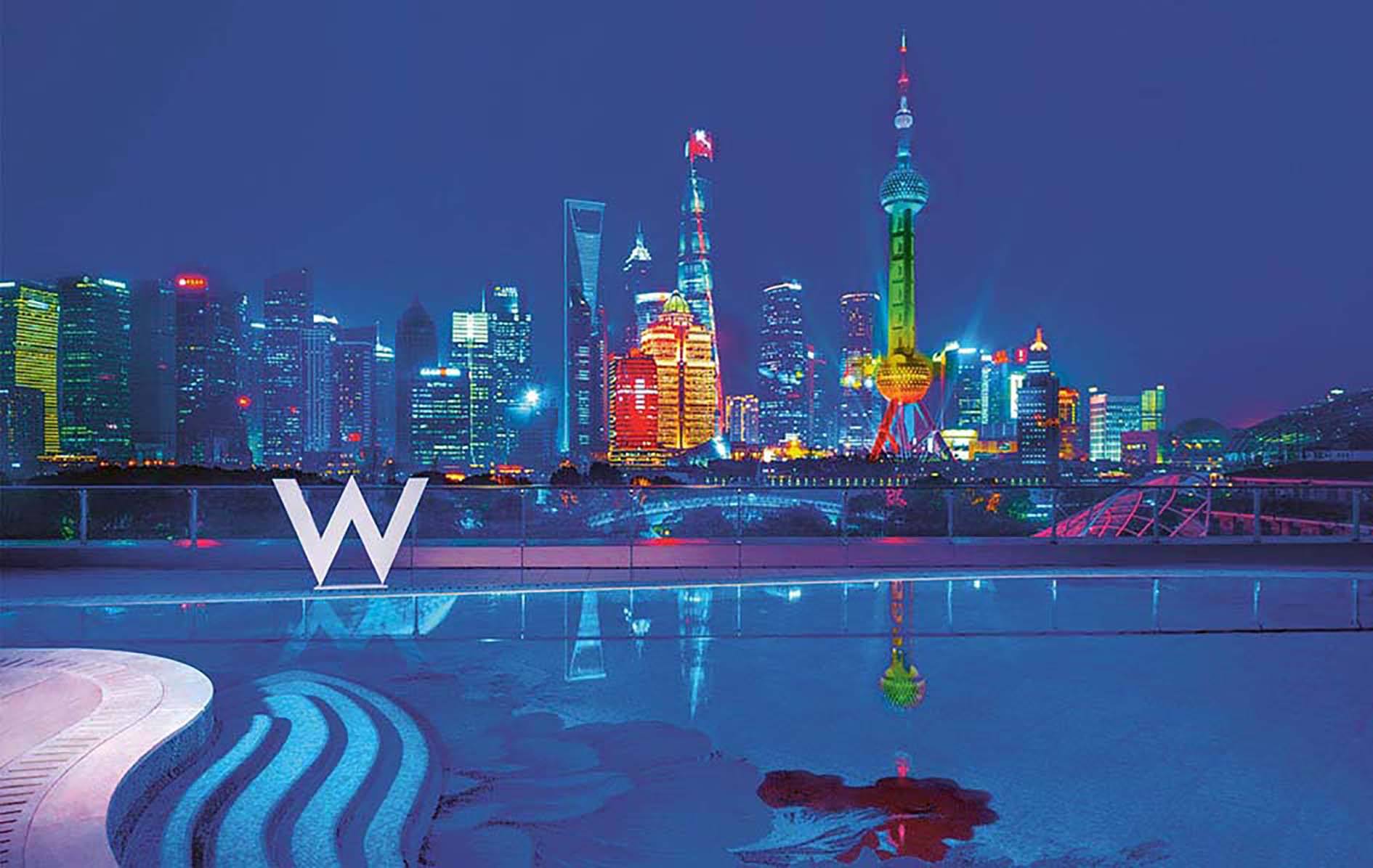 Wet rooftop bar and pool at the W Shanghai with nighttime neon skyline view of Shanghai