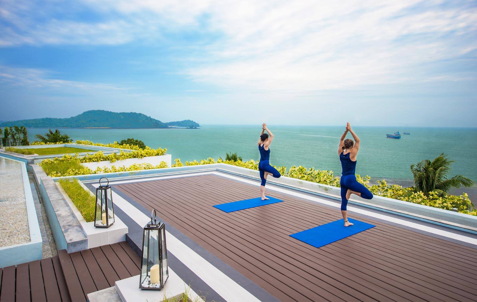 Outdoor yoga session overlooking the ocea at Amatara Wellness Resort in Phuket, Thailand