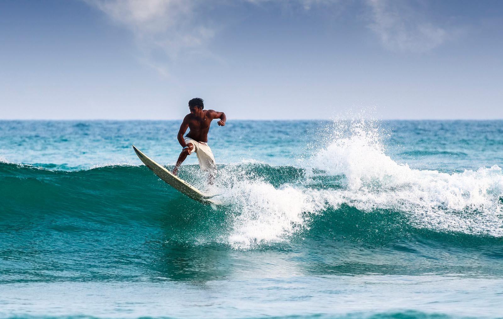 surfer riding wave in sri lanka
