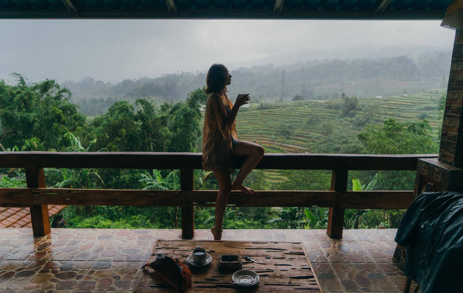 Girl holding coffee in front of balinese rice fields